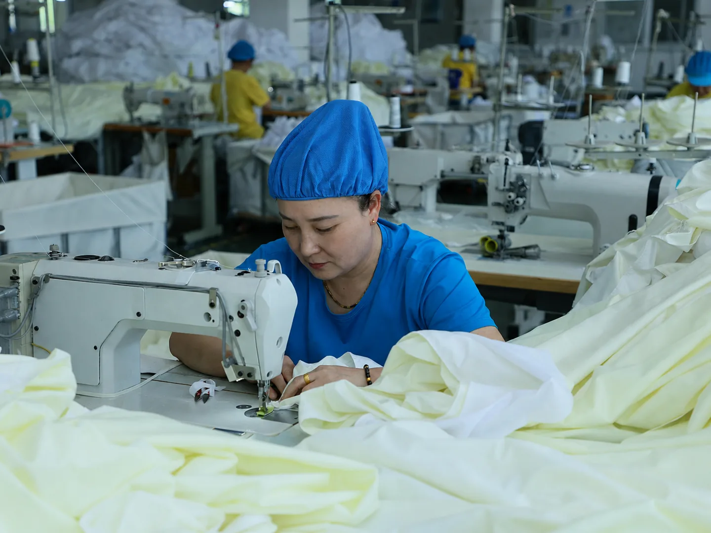 Blue-uniform sewing operator constructing functional bedding