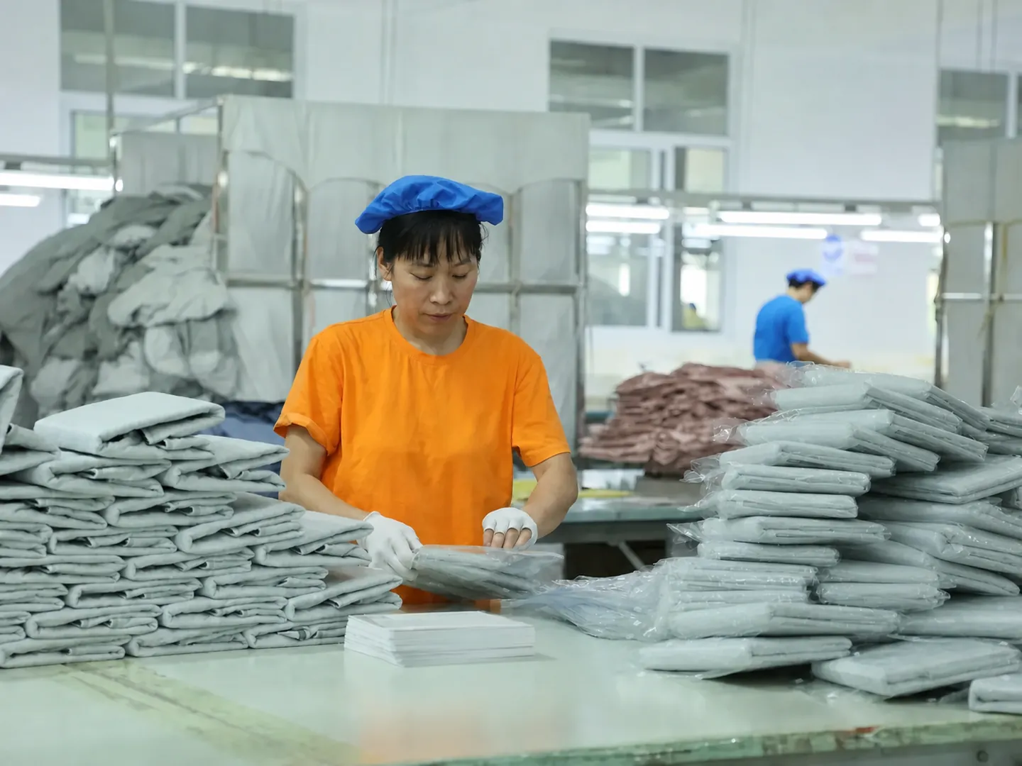 Orange-uniform packing operator placing a finished product into private-label packaging