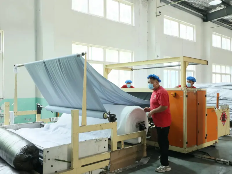 Incoming raw fabric opened and fed through inspection equipment before cutting